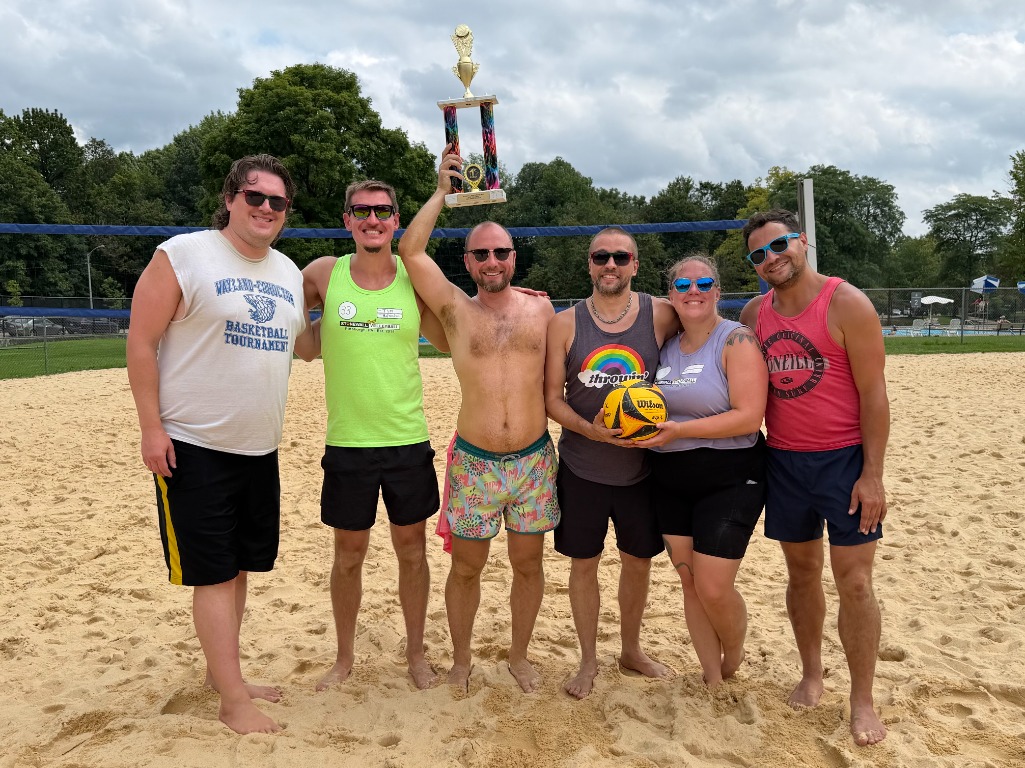 The Stonewall Sports Pittsburgh volleyball board together on the sand courts